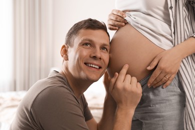 Young pregnant woman with her husband at home, closeup