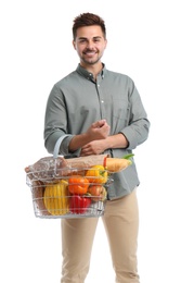 Young man with shopping basket full of products isolated on white