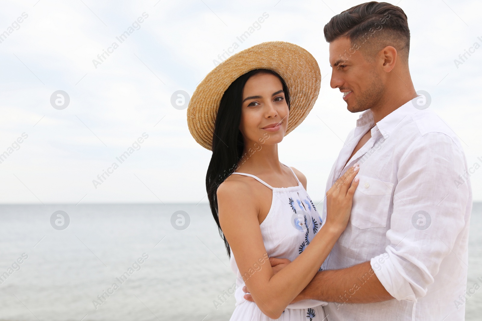 Photo of Lovely couple spending time together on beach. Space for text