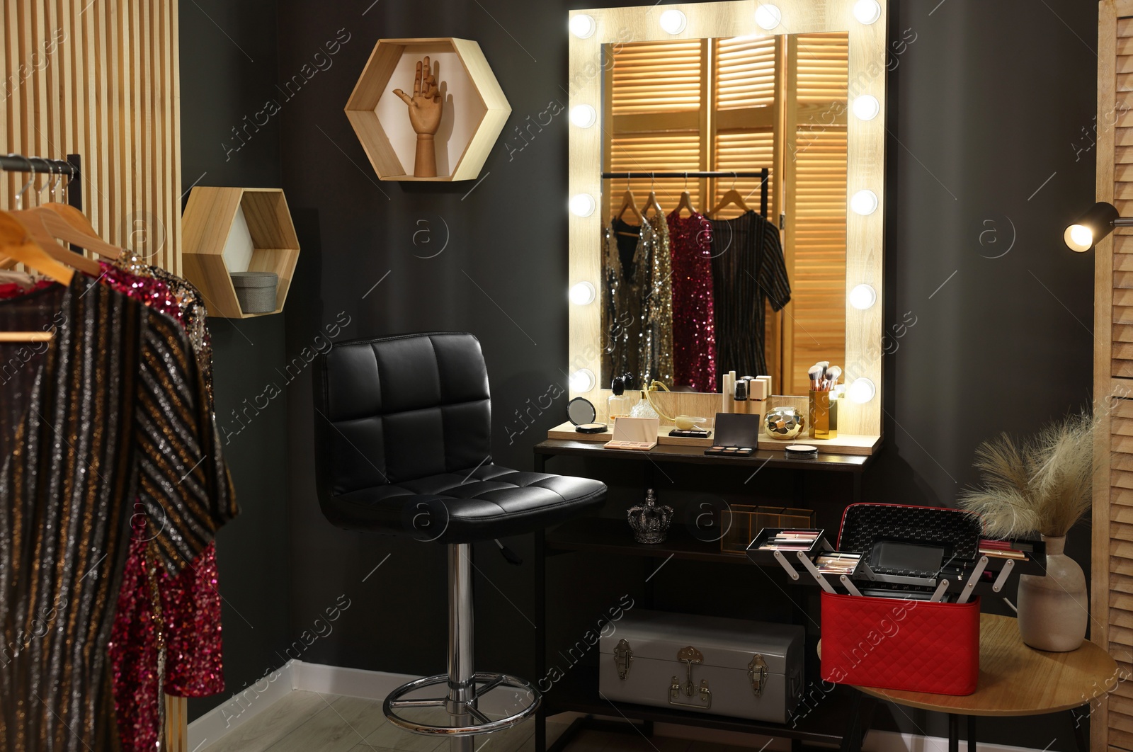 Photo of Makeup room. Stylish mirror near dressing table with beauty products and chair indoors