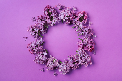 Photo of Frame made with beautiful lilac blossom on purple background, flat lay. Space for text