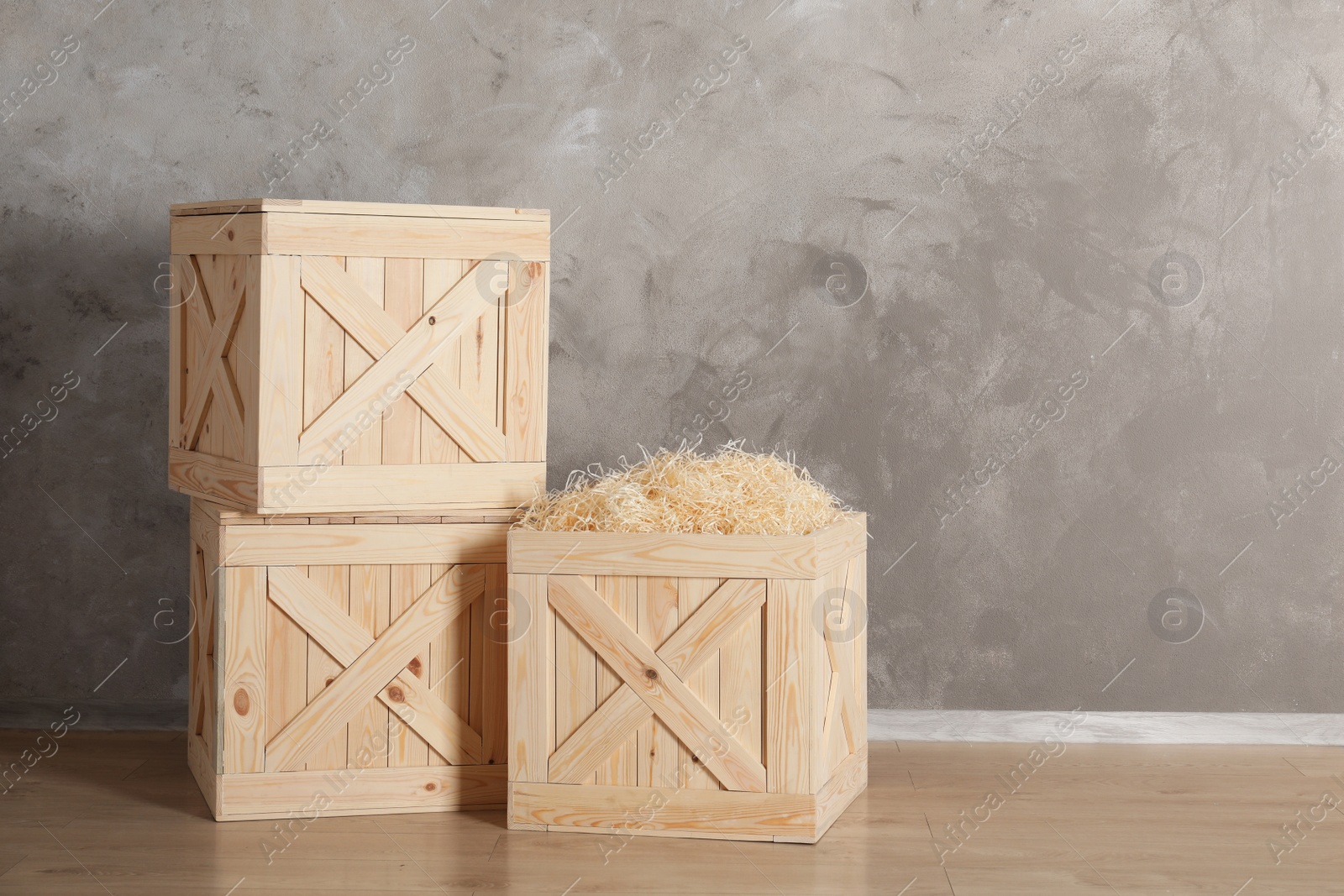 Photo of Wooden crates on floor against color background, space for text