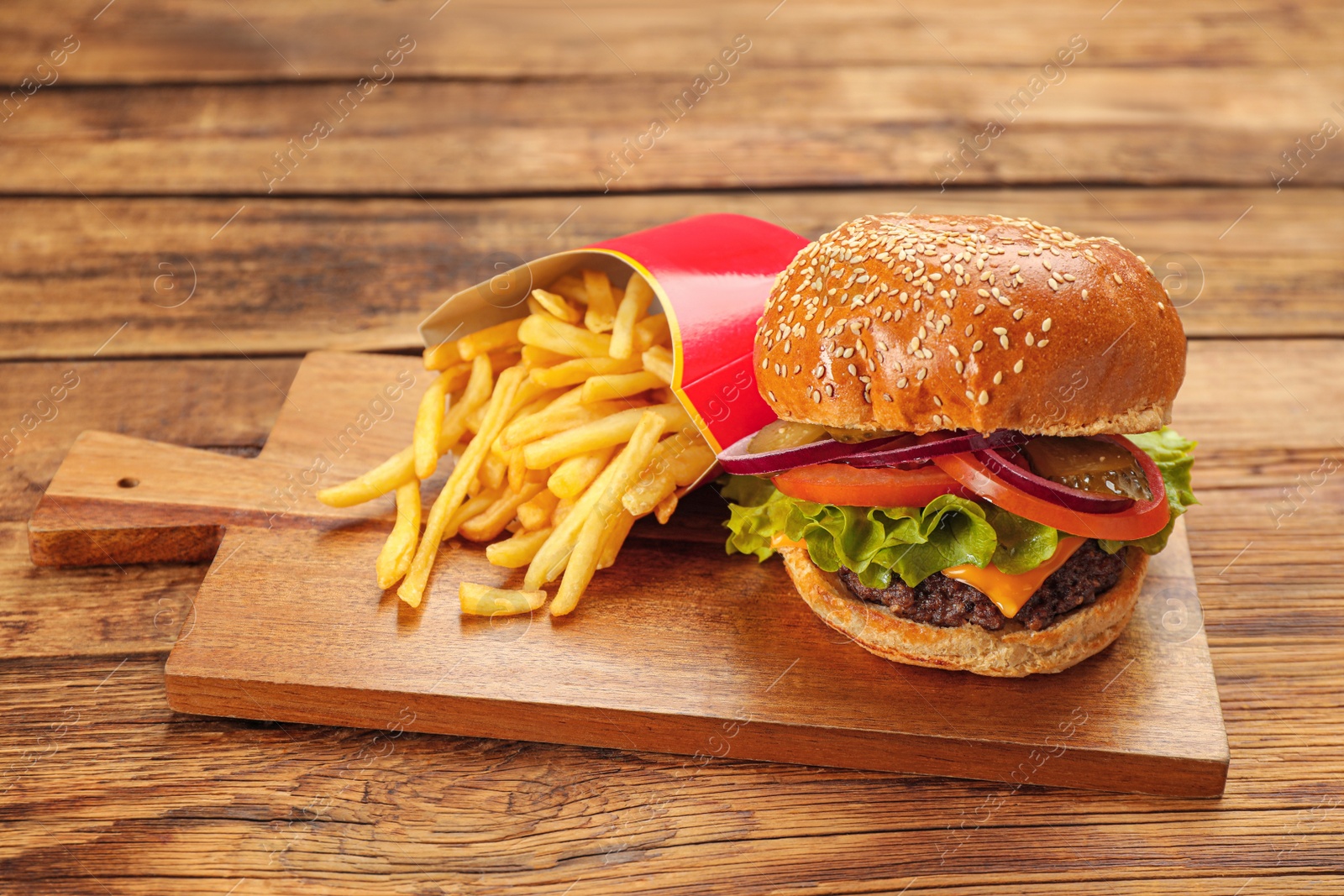 Photo of Tasty burger and French fries on wooden table. Fast food