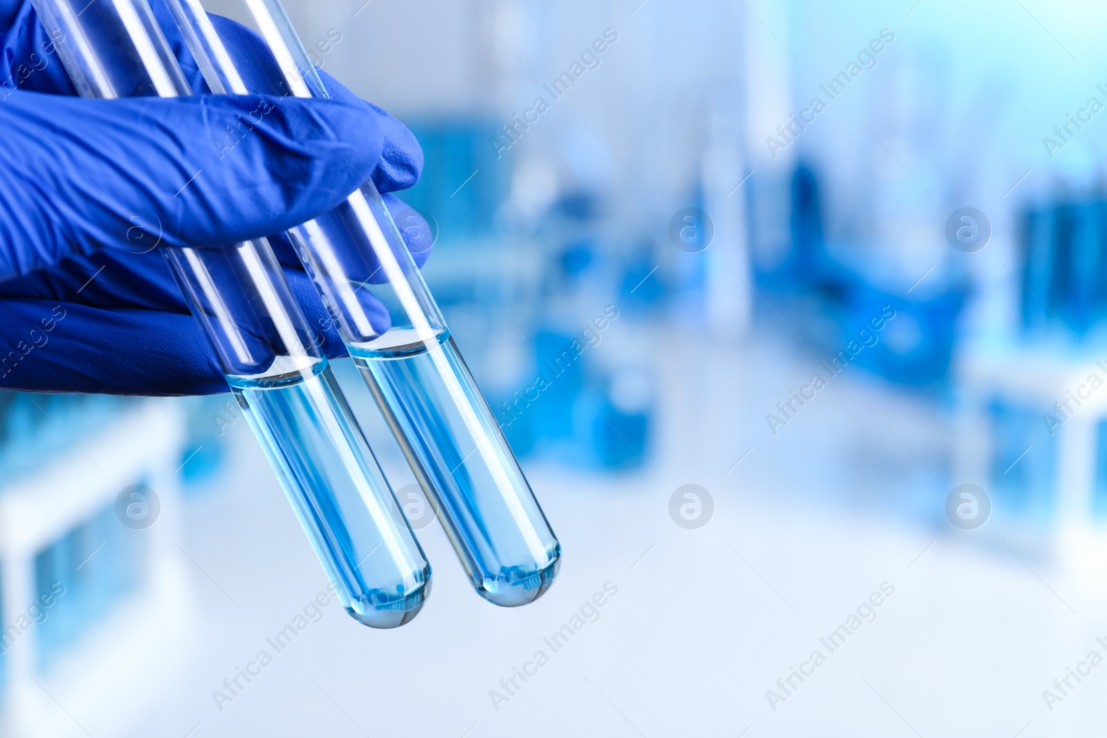 Photo of Doctor holding test tubes with samples for analysis in laboratory, closeup