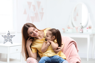 Young mother with little daughter at home