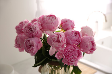 Photo of Vase with bouquet of beautiful pink peonies in kitchen, closeup