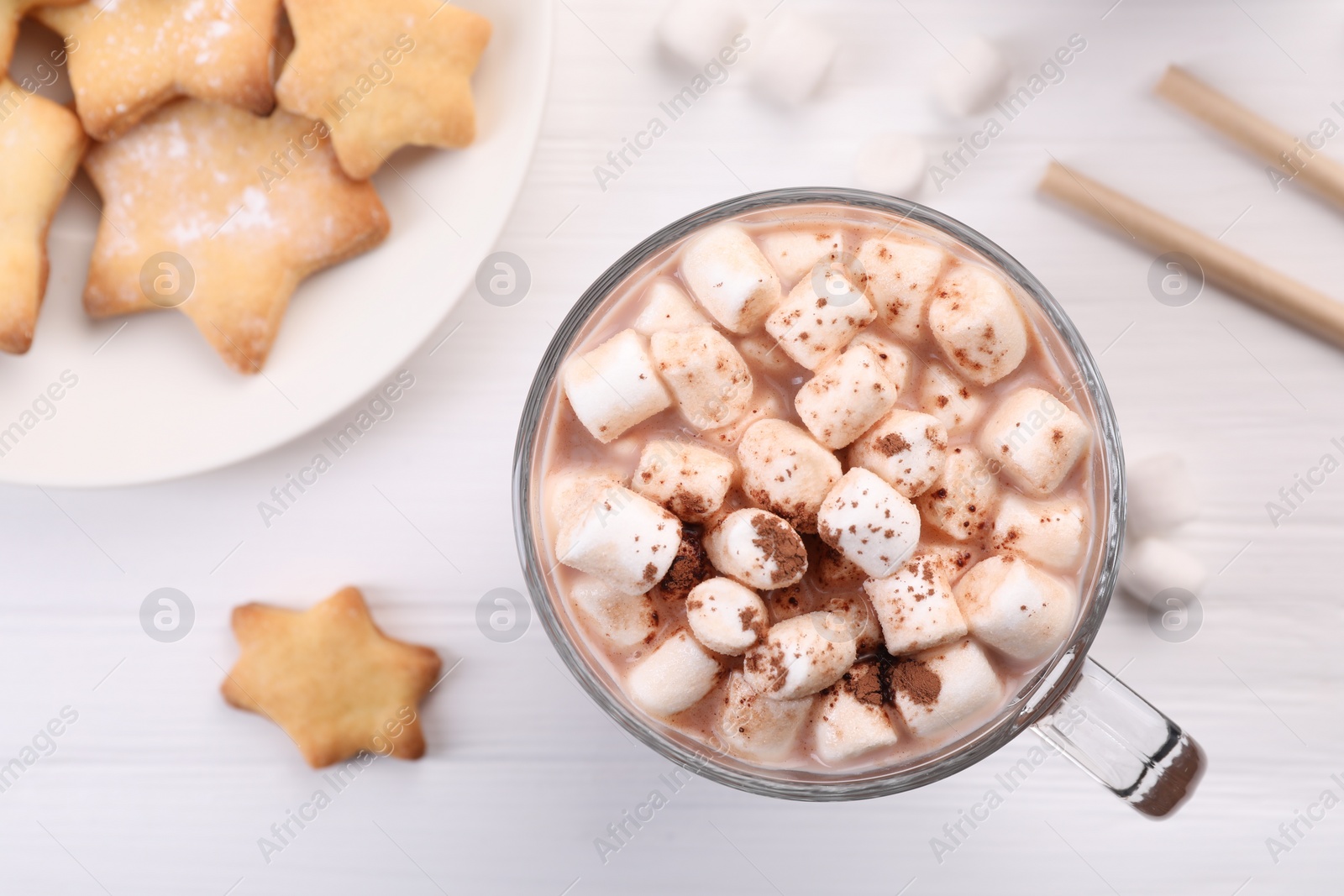 Photo of Cup of aromatic hot chocolate with marshmallows, cocoa powder and tasty cookies on white table, flat lay