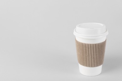 Photo of Paper cup with plastic lid on light background, space for text. Coffee to go