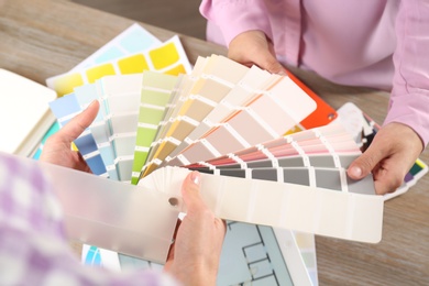 Photo of Women with palette samples at wooden table, above view