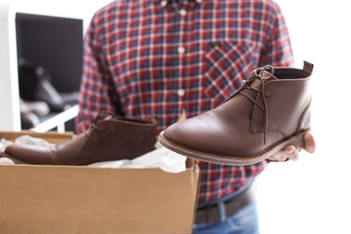 Young man choosing shoes in store