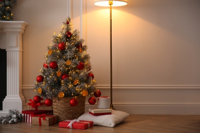 Photo of Beautiful Christmas tree and gift boxes in room. Space for text