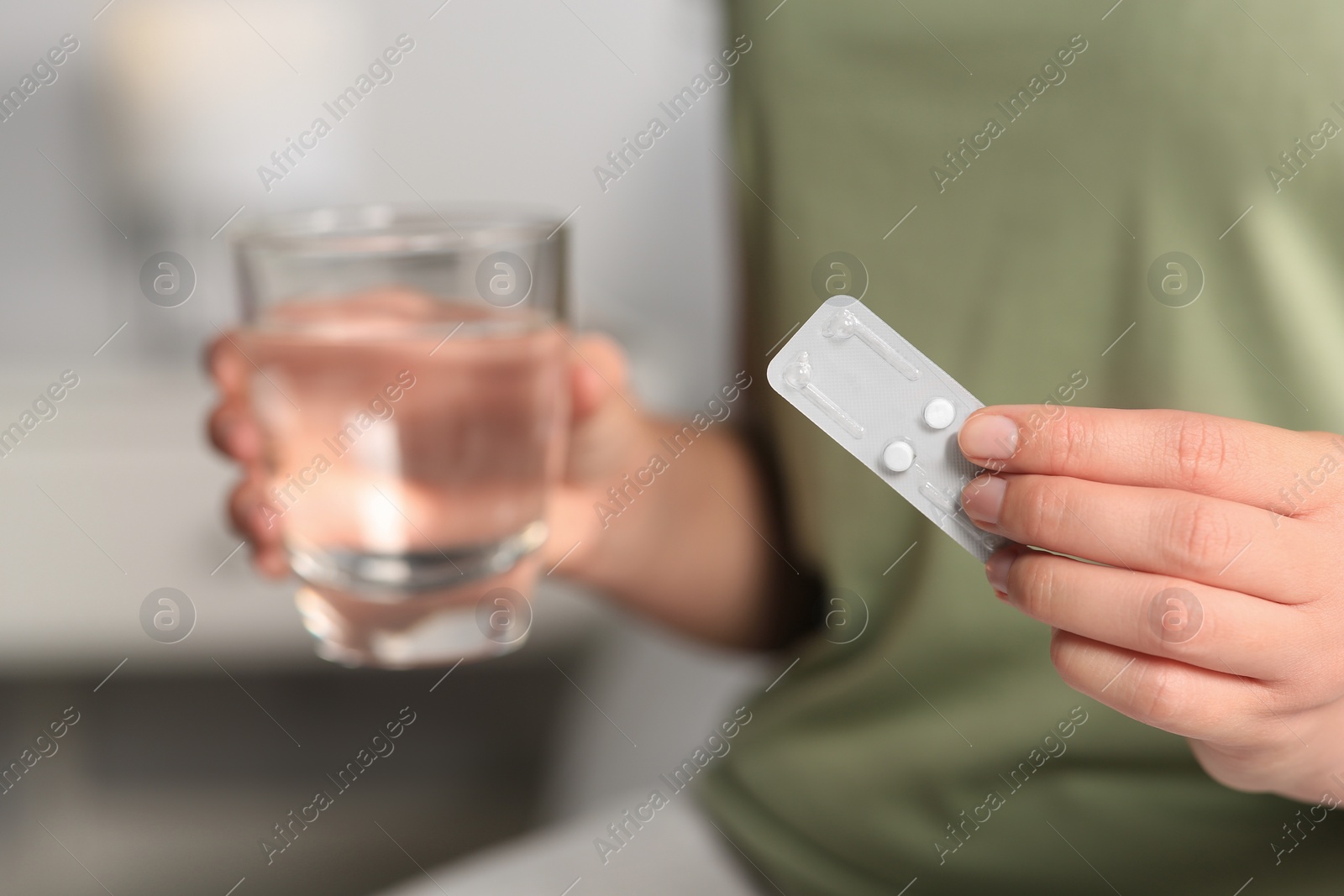 Photo of Woman taking emergency contraception pill in bedroom, focus on hand