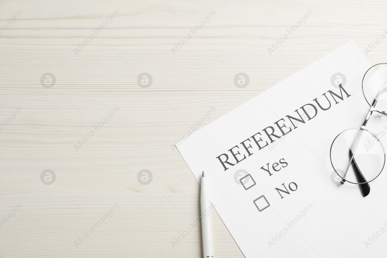 Photo of Referendum ballot with pen and glasses on white wooden table, flat lay. Space for text
