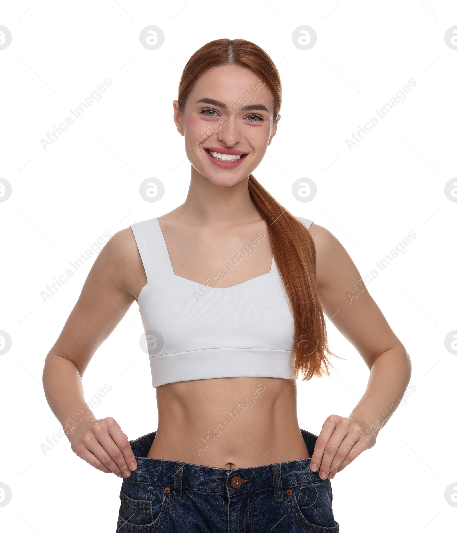 Photo of Slim woman wearing big jeans on white background. Weight loss