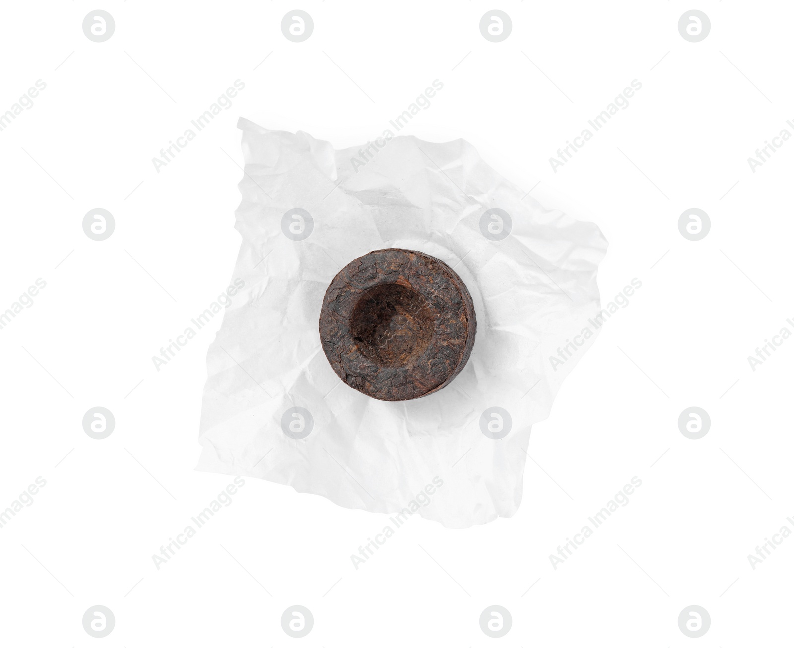Photo of Cake shaped traditional Chinese pu-erh tea in paper wrap isolated on white, top view