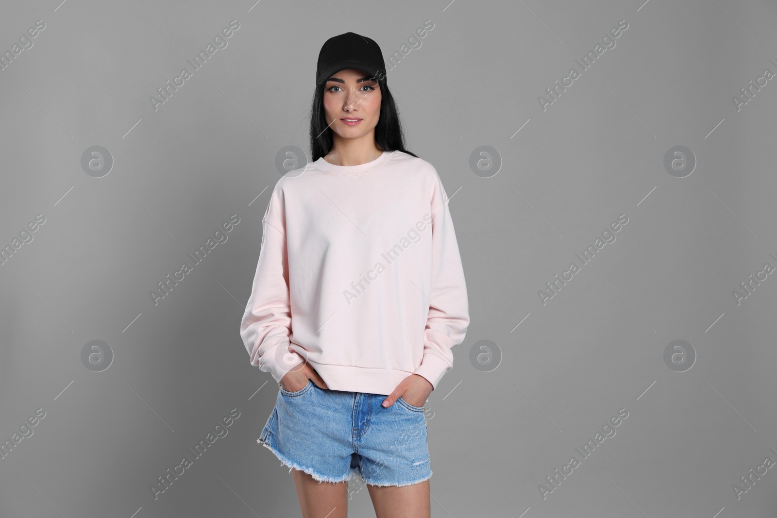 Photo of Portrait of young woman in sweater on grey background. Mock up for design