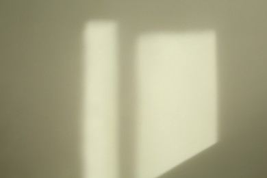 Photo of Light and shadow from window on beige wall indoors