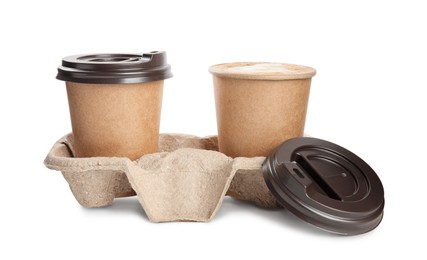 Takeaway paper cups with coffee in cardboard holder on white background