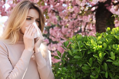 Photo of Woman suffering from seasonal pollen allergy outdoors
