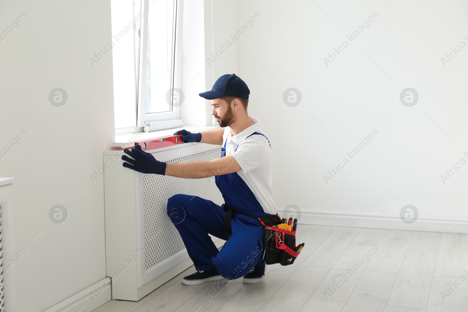 Photo of Handyman working with building level indoors. Professional construction tools