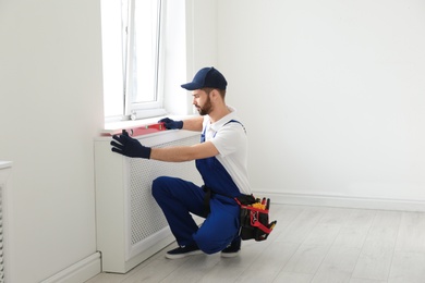 Handyman working with building level indoors. Professional construction tools