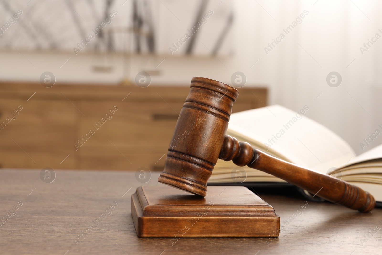 Photo of Wooden gavel and sound block on table indoors, closeup. Space for text