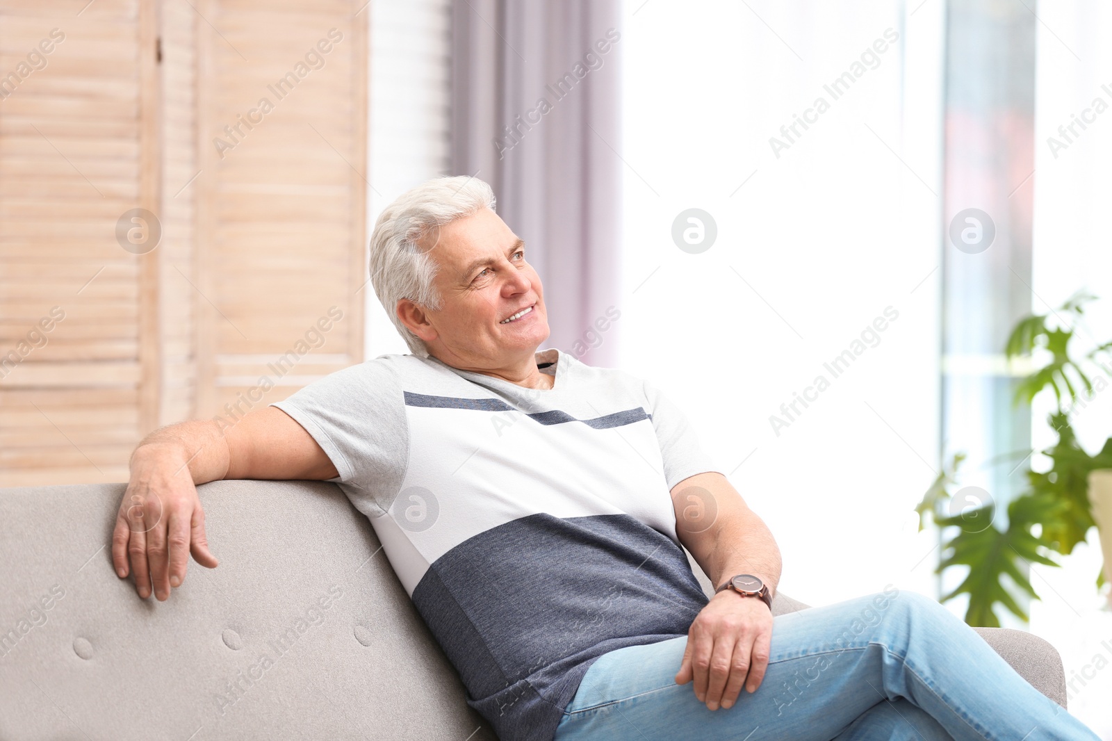 Photo of Portrait of handsome mature man on sofa indoors