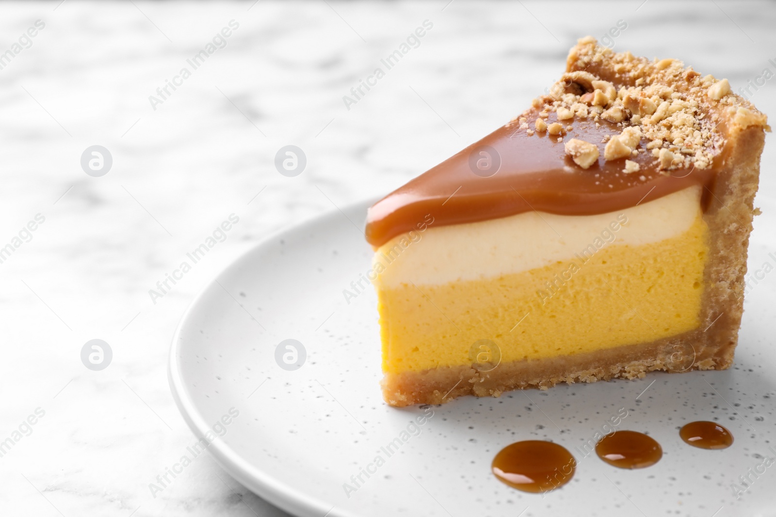 Photo of Piece of delicious cake with caramel on table. Space for text