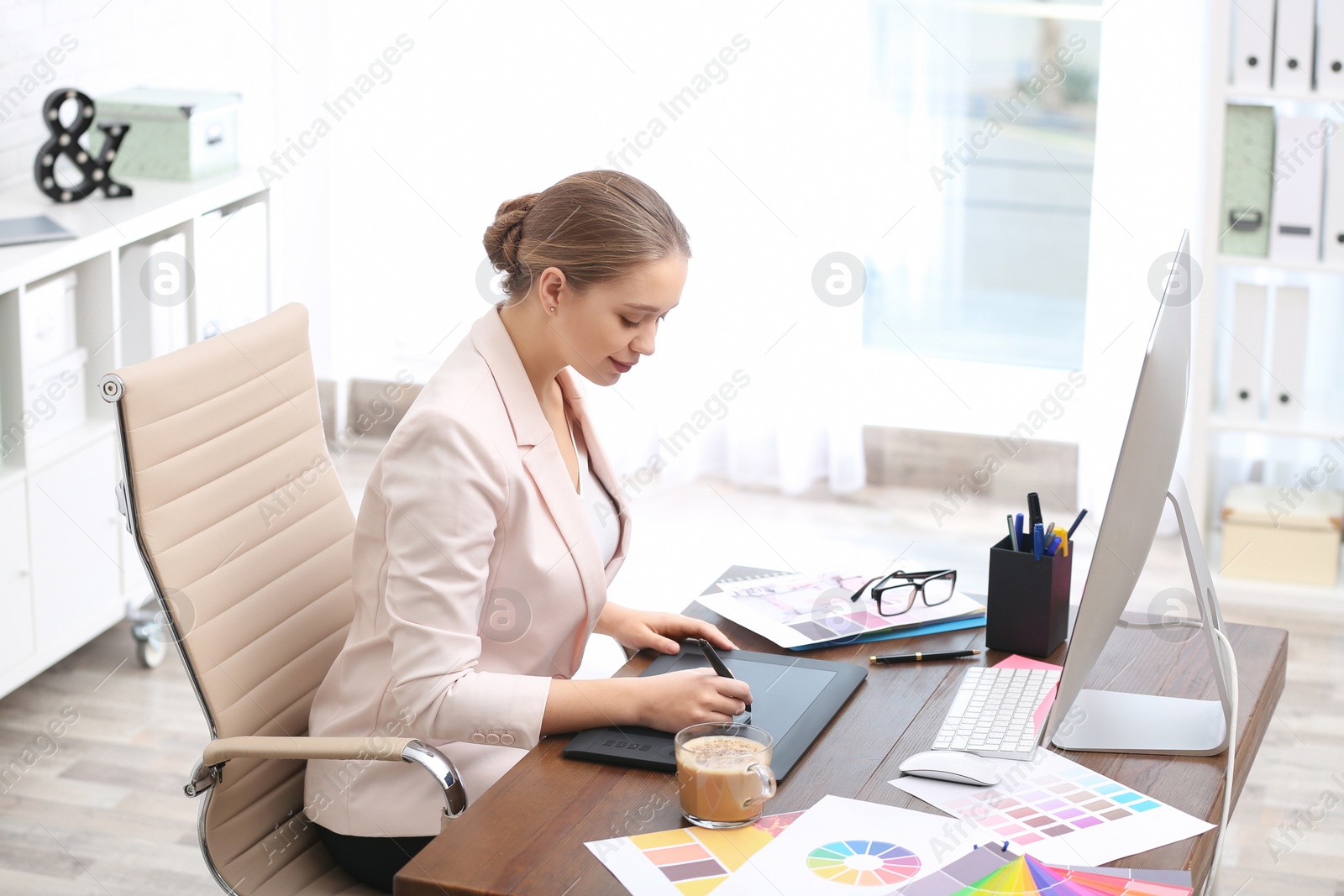 Photo of Female designer working at desk in office