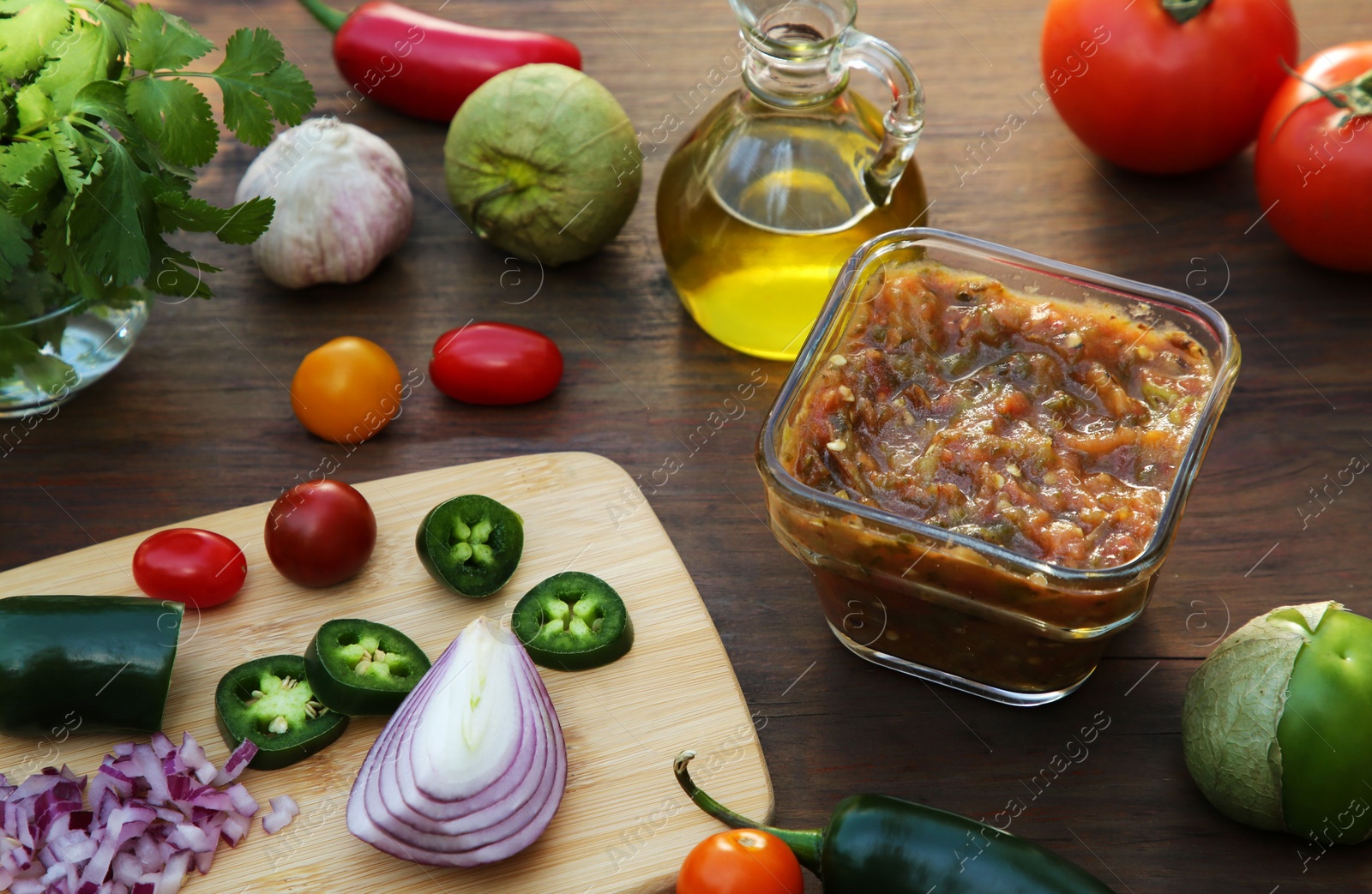 Photo of Tasty salsa sauce and ingredients on wooden table, view from above