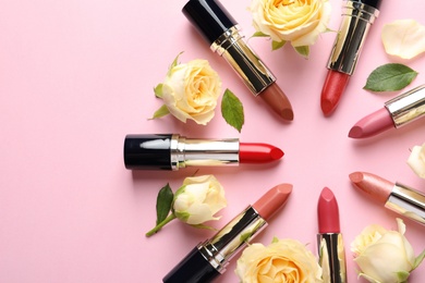 Photo of Flat lay composition with lipsticks and roses on color background. Space for text