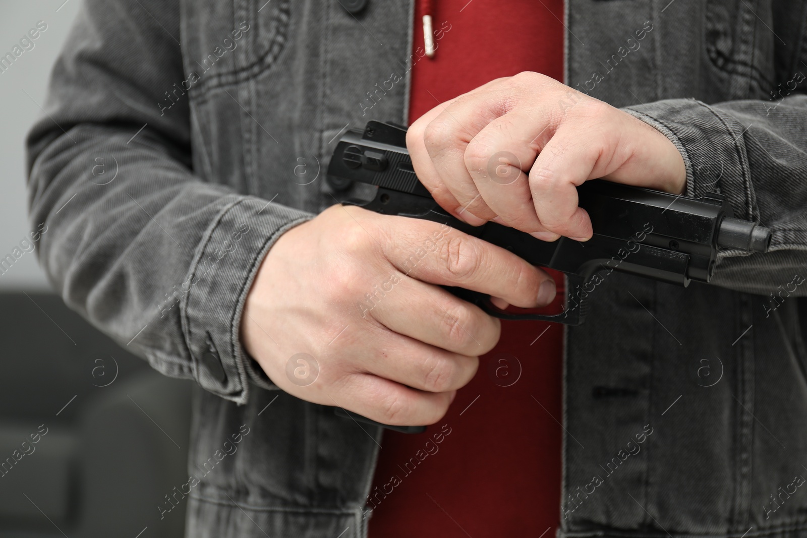 Photo of Dangerous criminal with gun in foreign house, closeup. Armed robbery