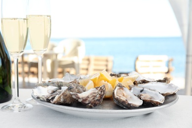 Photo of Fresh oysters with cut juicy lemon served on table