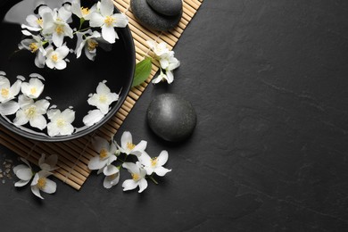 Photo of Beautiful spa composition with jasmine essential oil and fresh flowers on table, flat lay. Space for text