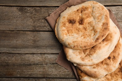 Photo of Delicious fresh pita bread on wooden table, top view. Space for text