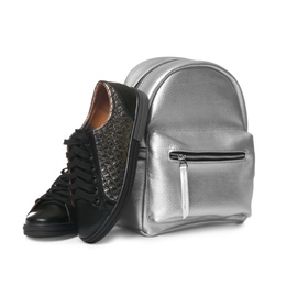 Pair of modern shoes and stylish backpack on white background