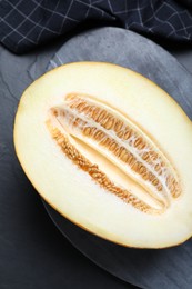 Photo of Delicious honey melon on black table, top view