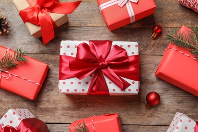 Photo of Beautiful composition with gift boxes and Christmas decorations on wooden background, top view