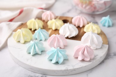 Photo of Tray with tasty meringue cookies on white marble table, closeup