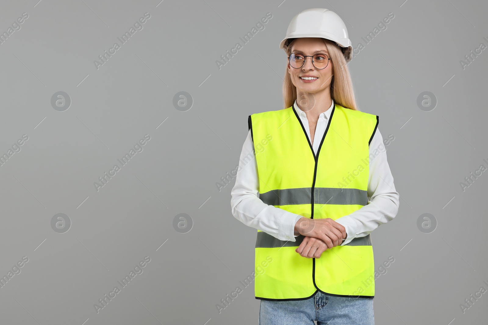 Photo of Engineer in hard hat on grey background, space for text