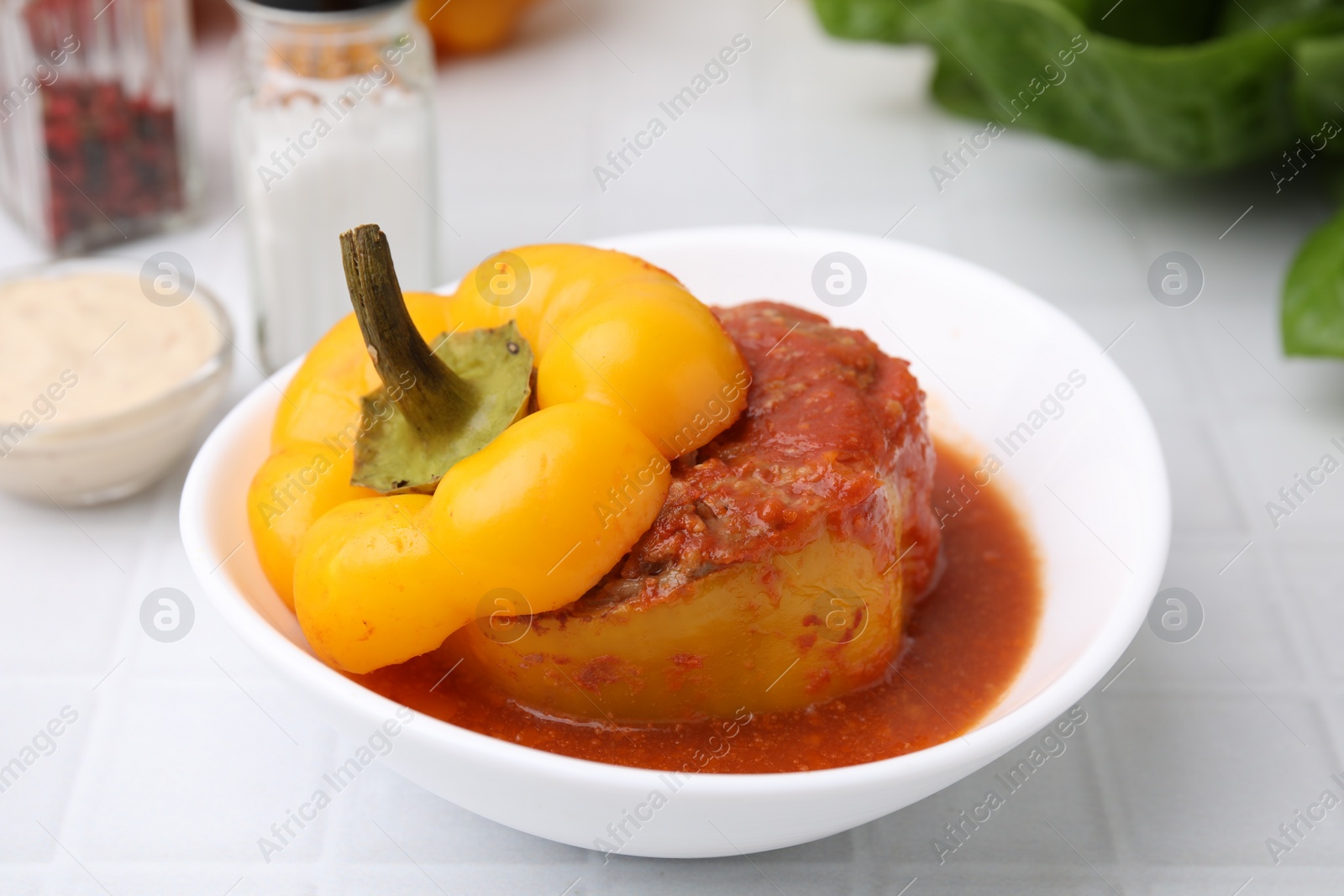 Photo of Delicious stuffed bell pepper on white tiled table