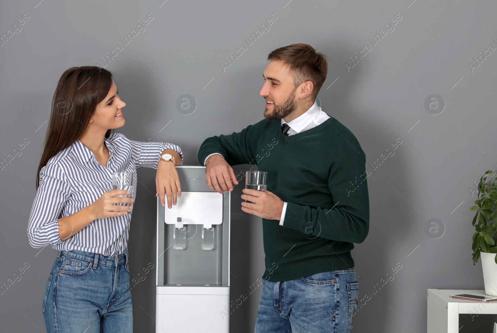 Photo of Employees having break near water cooler in office