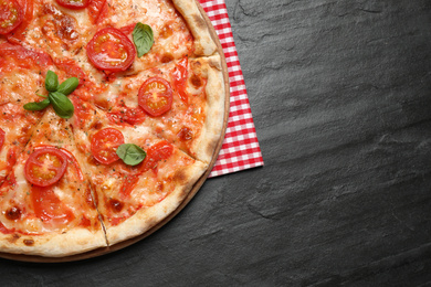 Photo of Delicious pizza Margherita on dark grey table, top view. Space for text