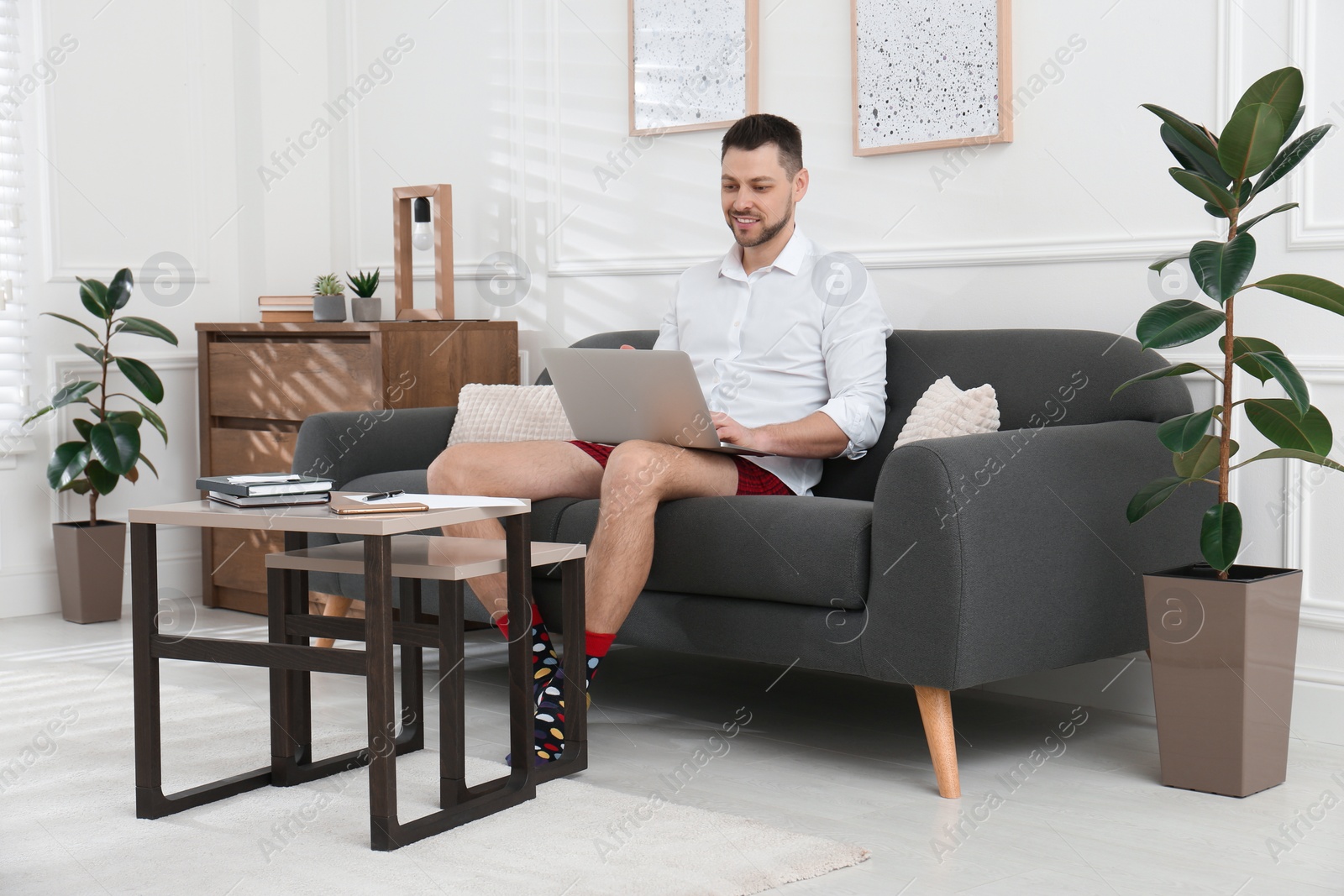 Photo of Businessman wearing shirt and underwear during video call at home