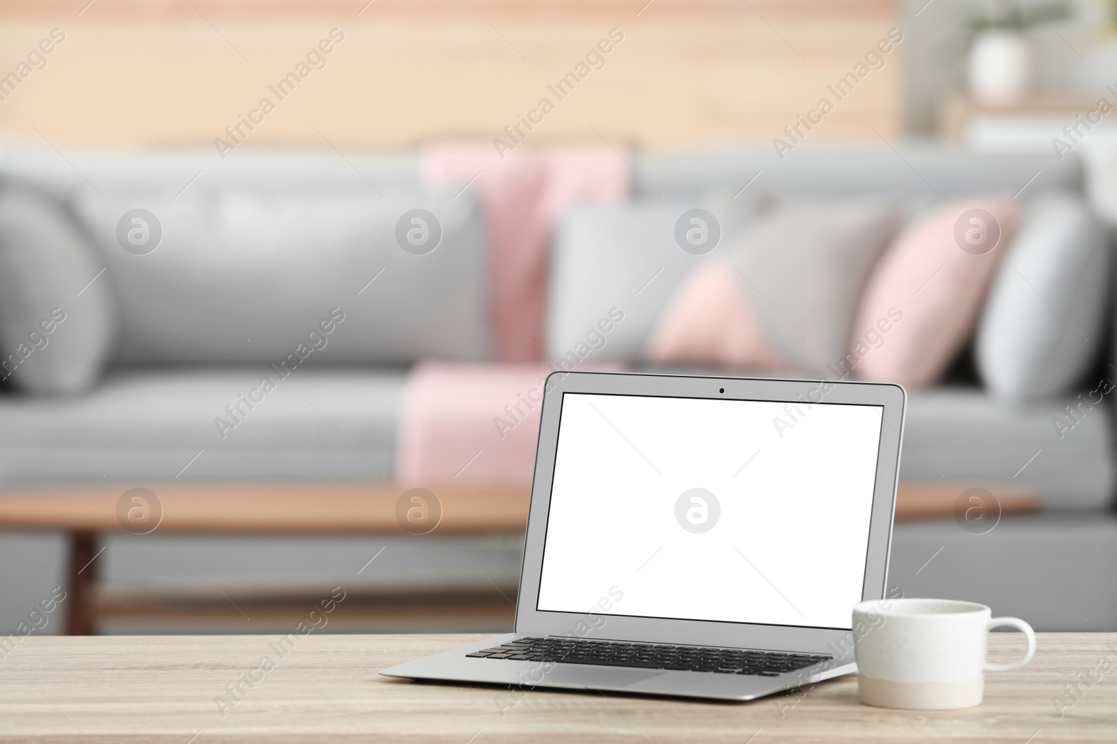 Photo of Laptop with blank screen on table indoors. Space for text