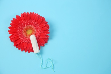 Flat lay composition with flower and tampon on color background. Gynecological checkup