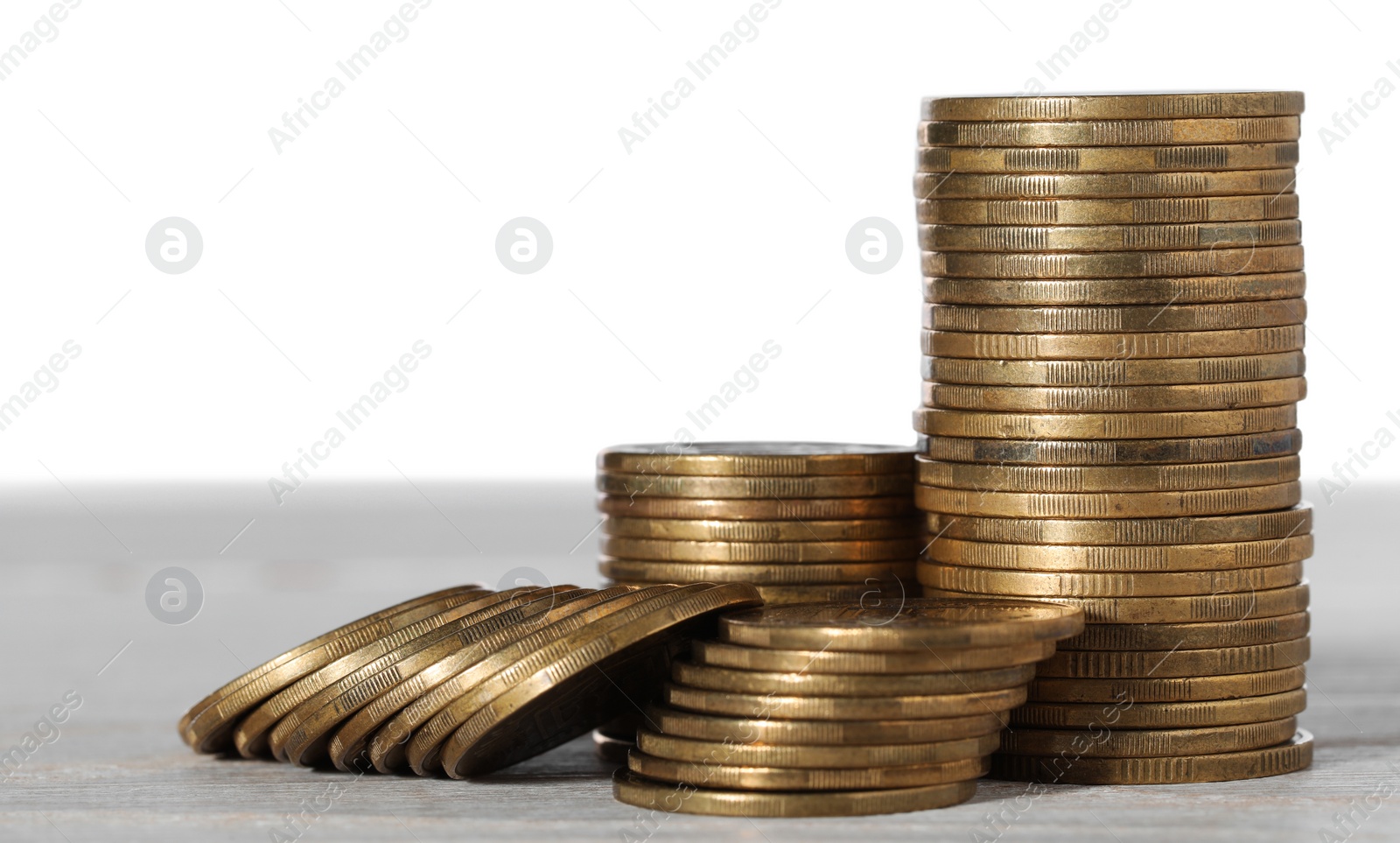 Photo of Stack of coins on wooden table, closeup