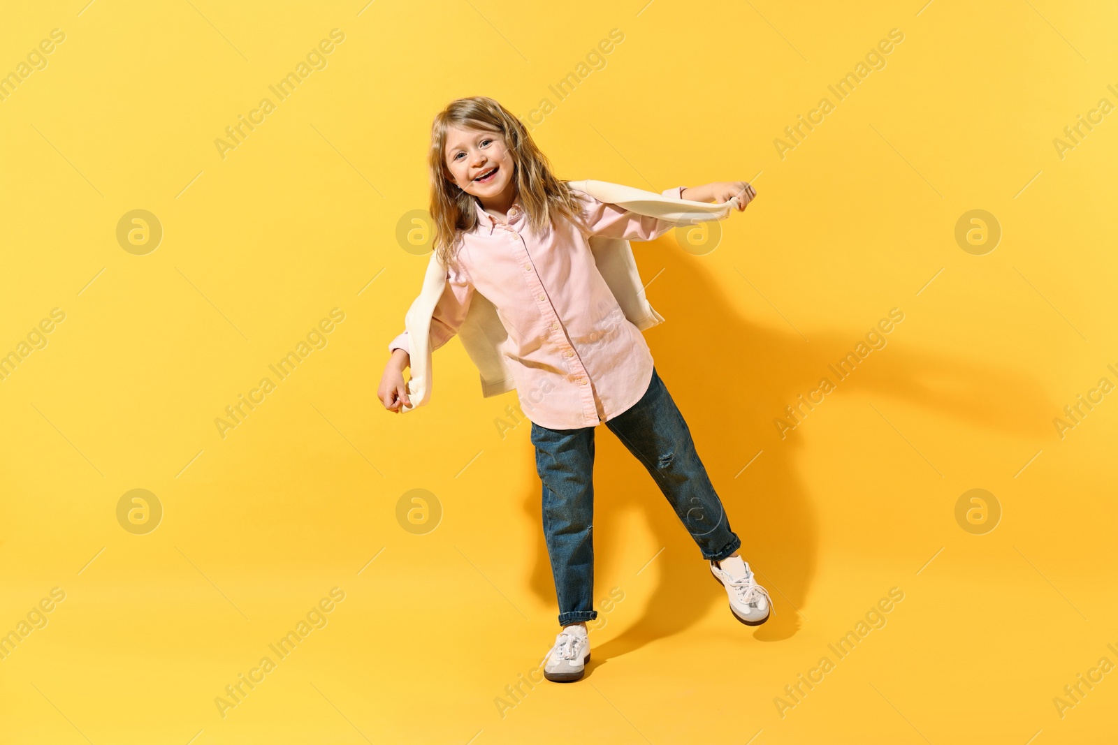 Photo of Fashion concept. Stylish girl posing on yellow background