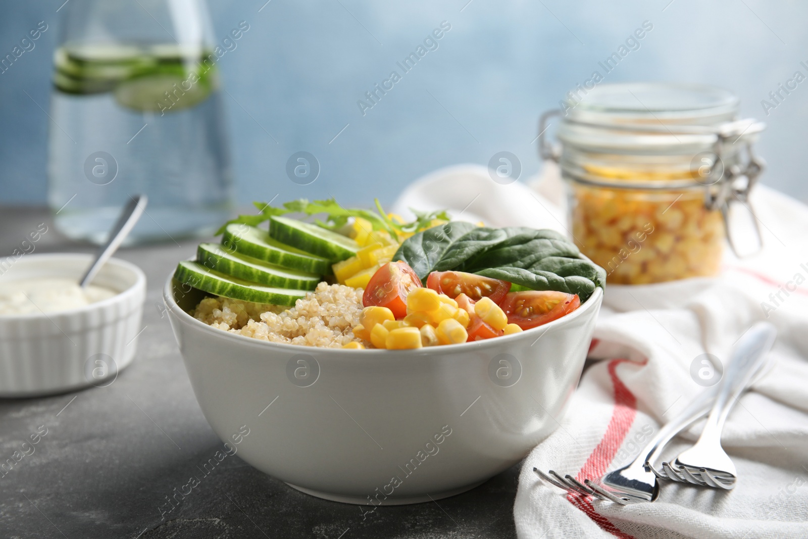 Photo of Healthy quinoa salad with vegetables in bowl served on table