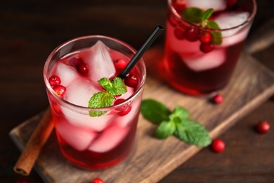 Tasty refreshing cranberry cocktail with mint on wooden table, closeup. Space for text